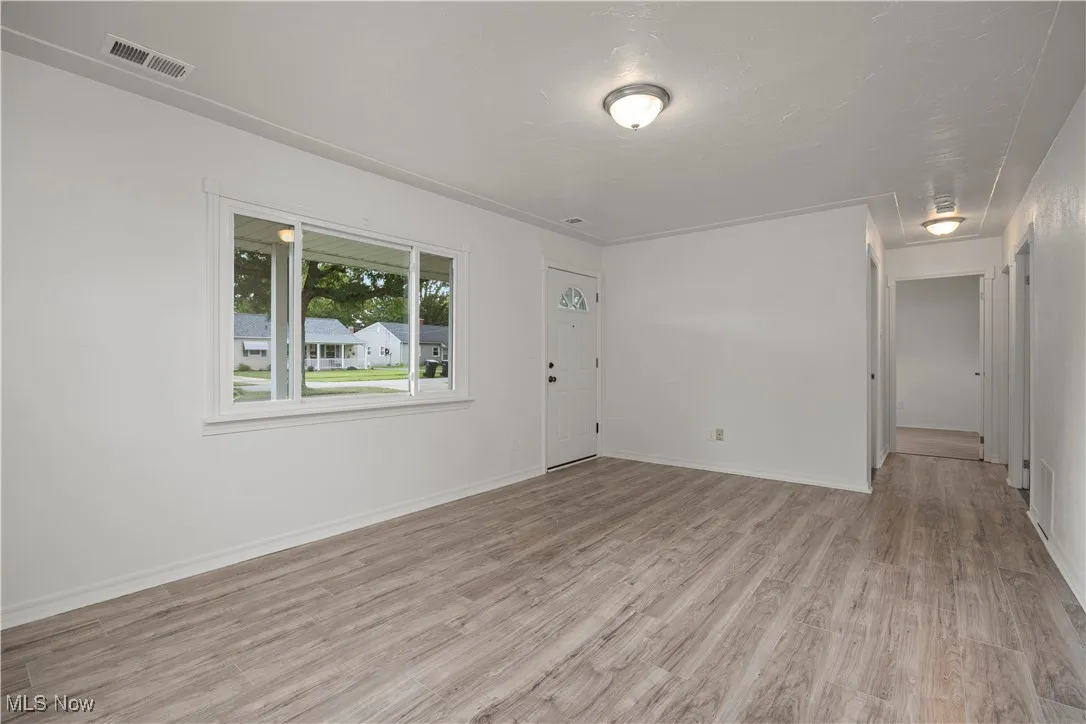 Unfurnished room with light wood-style floors and baseboards