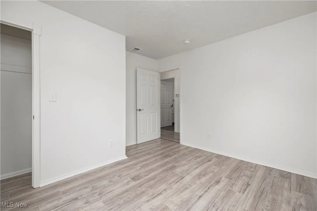 Unfurnished bedroom featuring light wood-style floors and baseboards