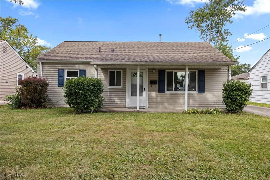 View of front of house featuring a front yard and a shingled roof