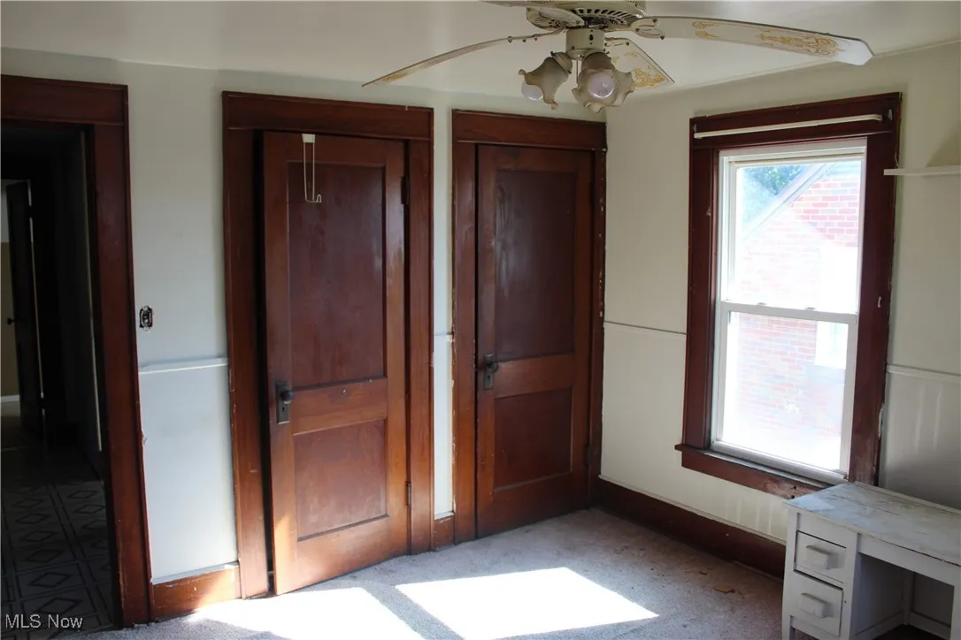 Unfurnished bedroom featuring multiple closets, a ceiling fan, and carpet floors