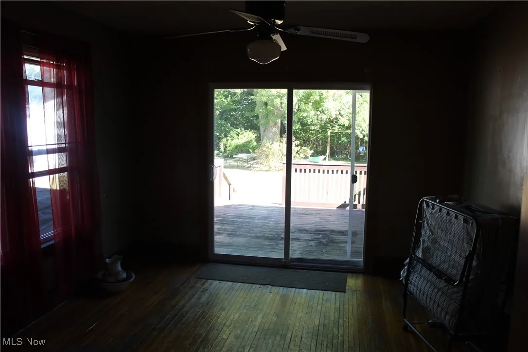 Doorway to outside featuring wood-type flooring and a ceiling fan