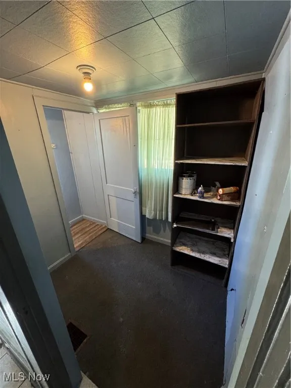 Unfurnished bedroom with a closet and dark carpet