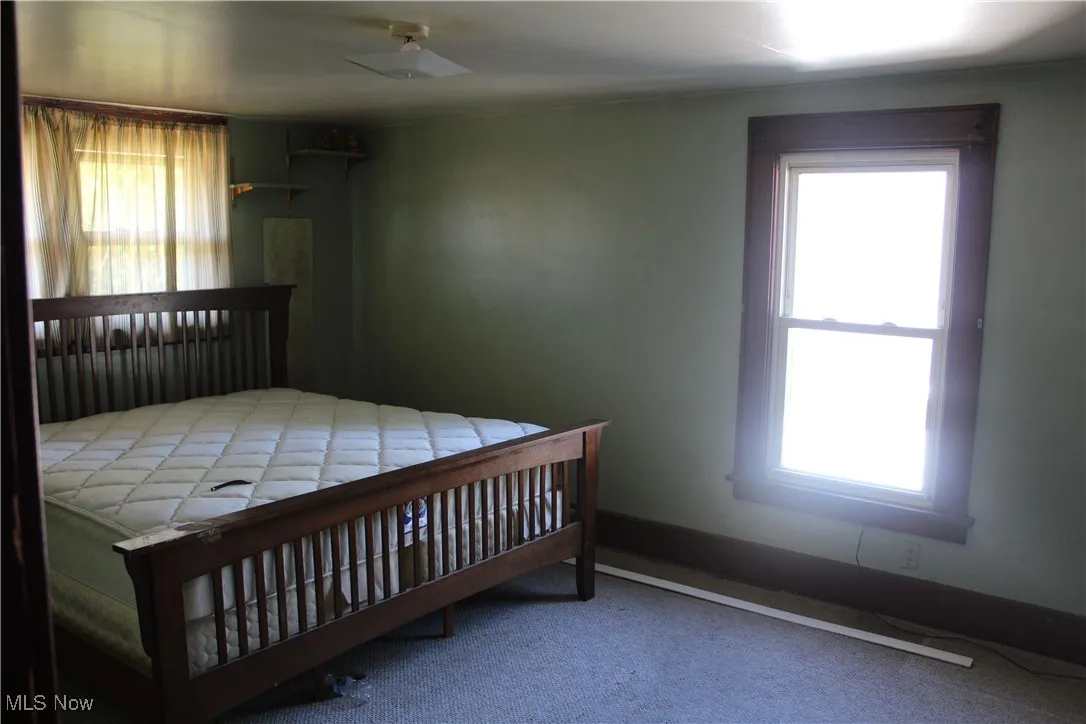 Bedroom featuring carpet and baseboards