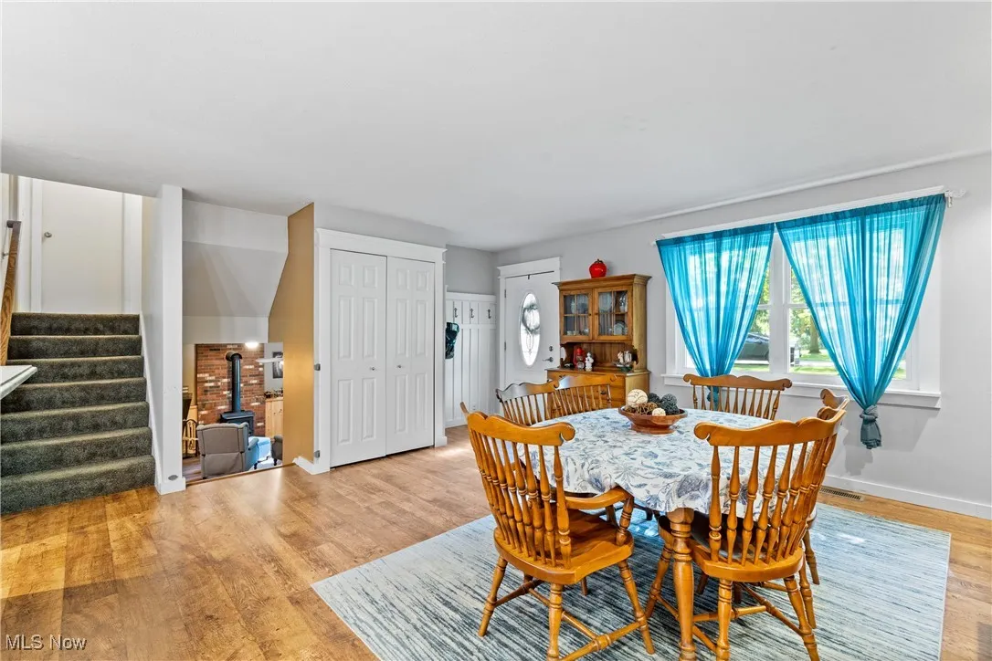 Dining space with stairway and light wood-style flooring