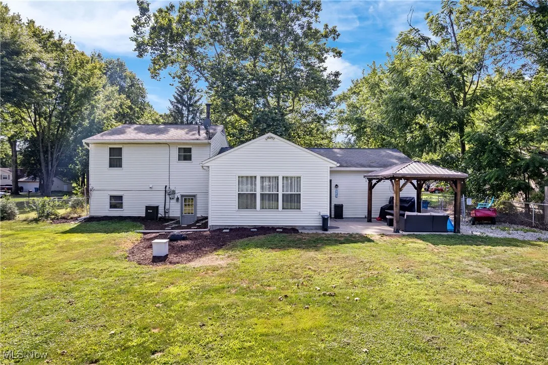 Rear view of house with a gazebo, a patio, a lawn, and outdoor lounge area