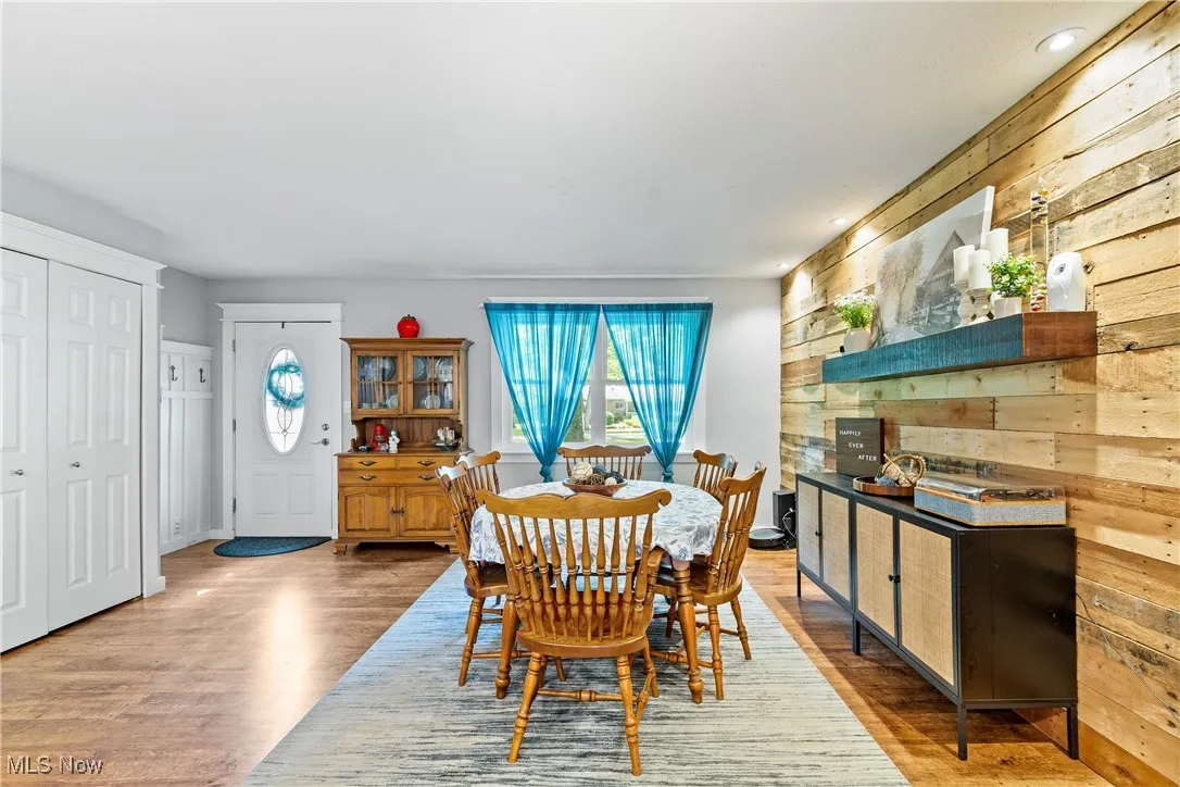 Dining space with wooden walls and light wood finished floors