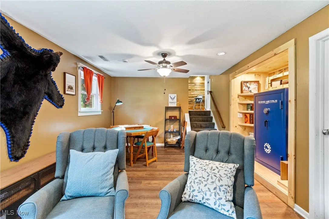 Living area featuring wood finished floors, stairs, and ceiling fan