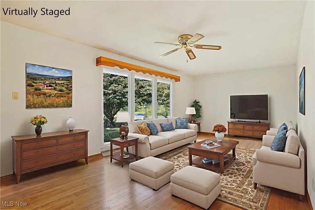 Living area with light wood finished floors and ceiling fan