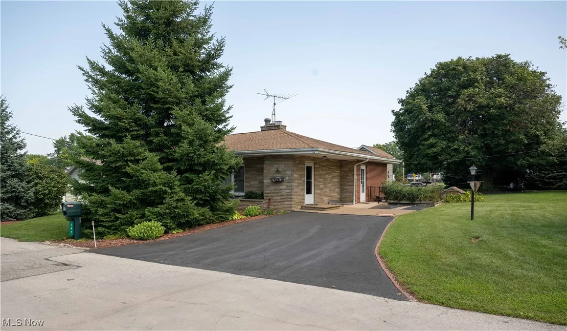 View of front of house with a front lawn, brick siding, and a chimney