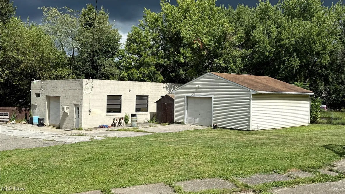 Rear view of house featuring a shop, a garage, and concrete driveway