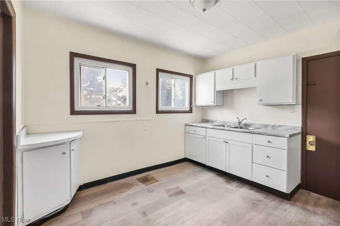 Kitchen featuring white cabinets, light countertops, and light wood-style floors