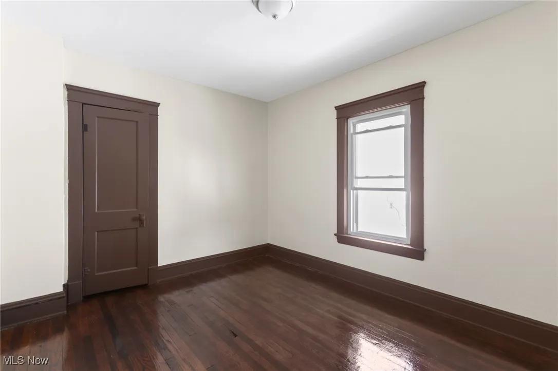 Spare room featuring dark wood-type flooring