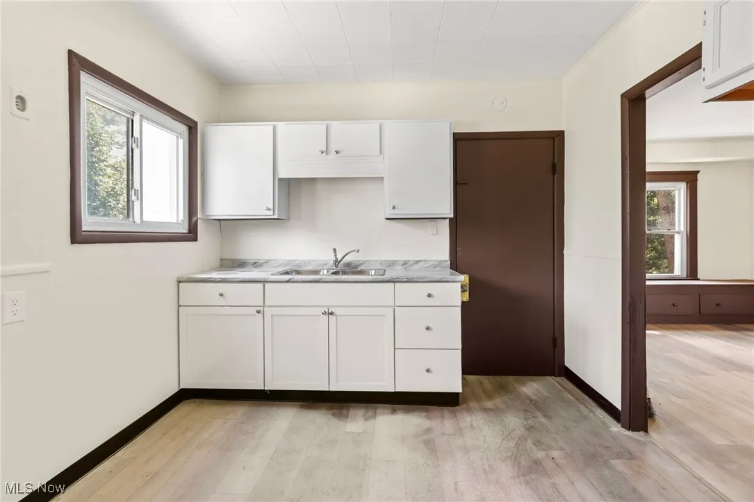 Kitchen with white cabinets, light countertops, plenty of natural light, and light wood-type flooring
