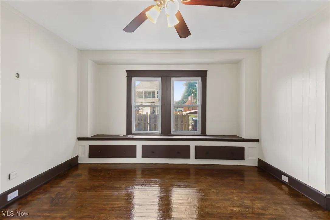 Unfurnished room with dark wood-type flooring, a ceiling fan, and wooden​​‌​​​​‌​​‌‌​‌‌​​​‌‌​‌​‌​‌​​​‌​​ walls