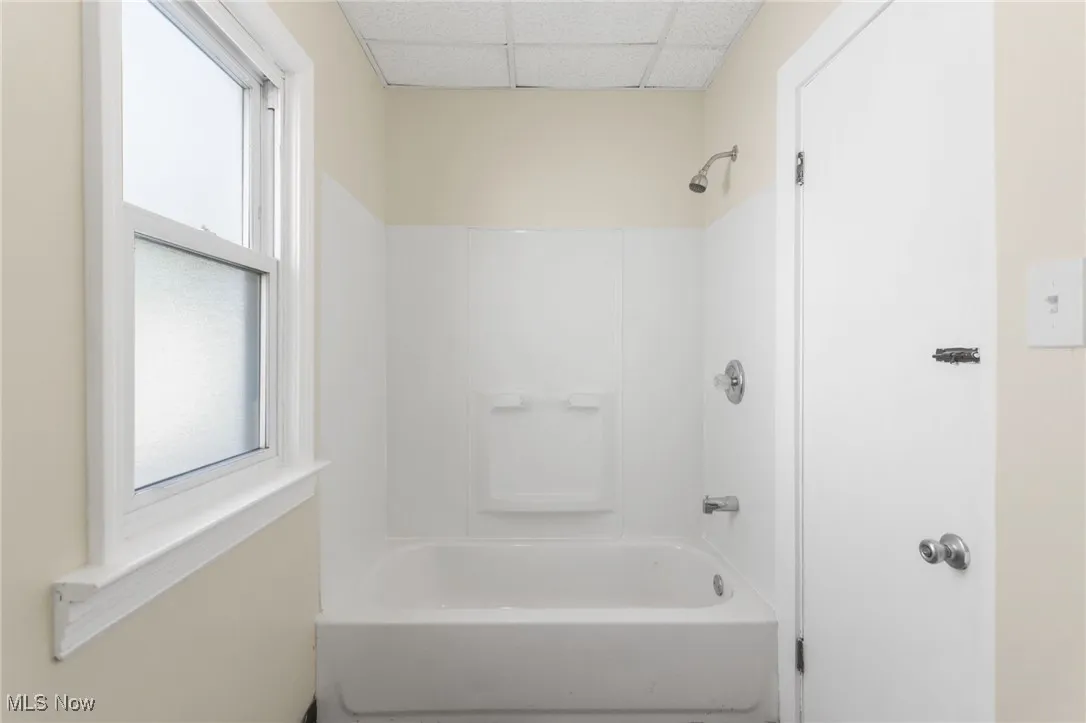 Bathroom with bathing tub / shower combination and a drop ceiling