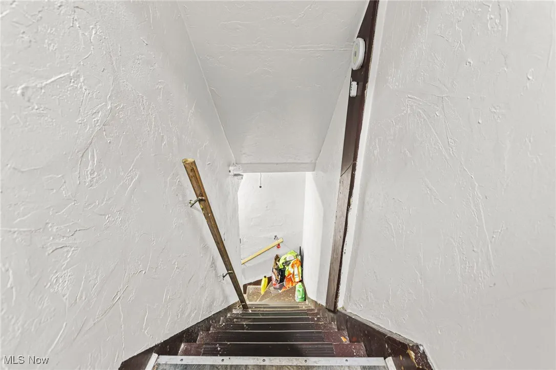 Stairway featuring a textured wall