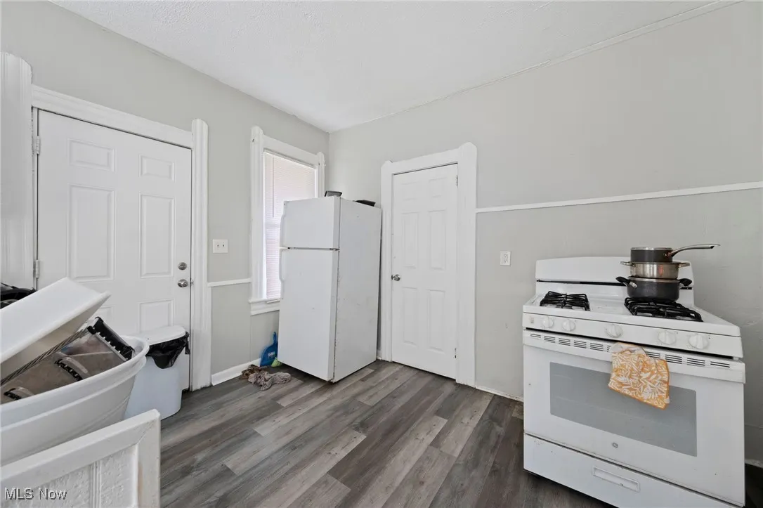 Kitchen with white appliances and dark wood-style floors