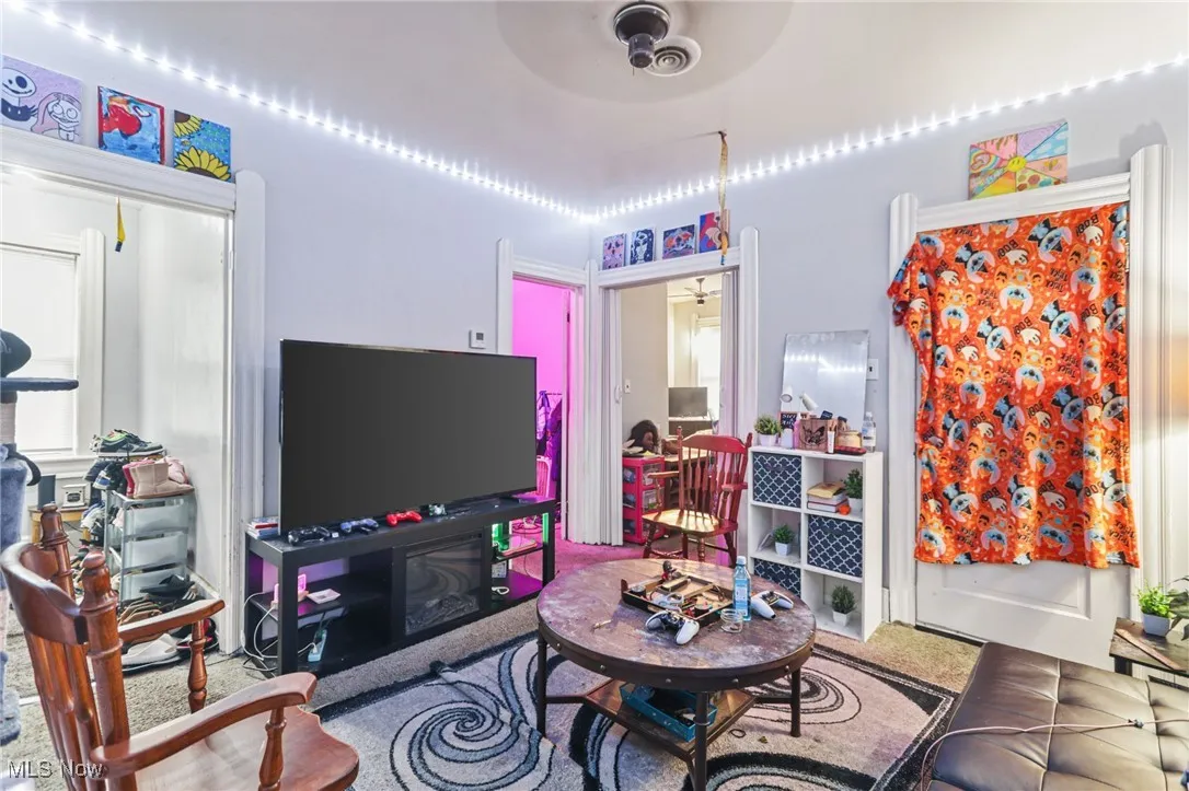 Living area featuring a ceiling fan and carpet flooring