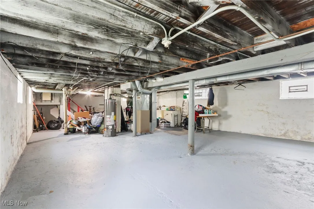 Basement featuring healthy amount of natural light, gas water heater, and heating unit
