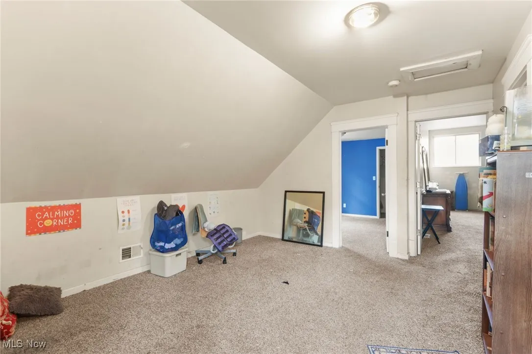 Bonus room featuring carpet floors, vaulted ceiling, and attic access
