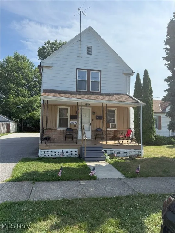 Bungalow-style home featuring a front yard, a porch, a shingled roof, and board and batten siding