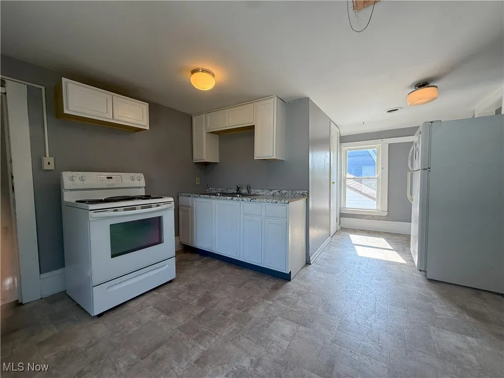 Kitchen with white appliances and white cabinets