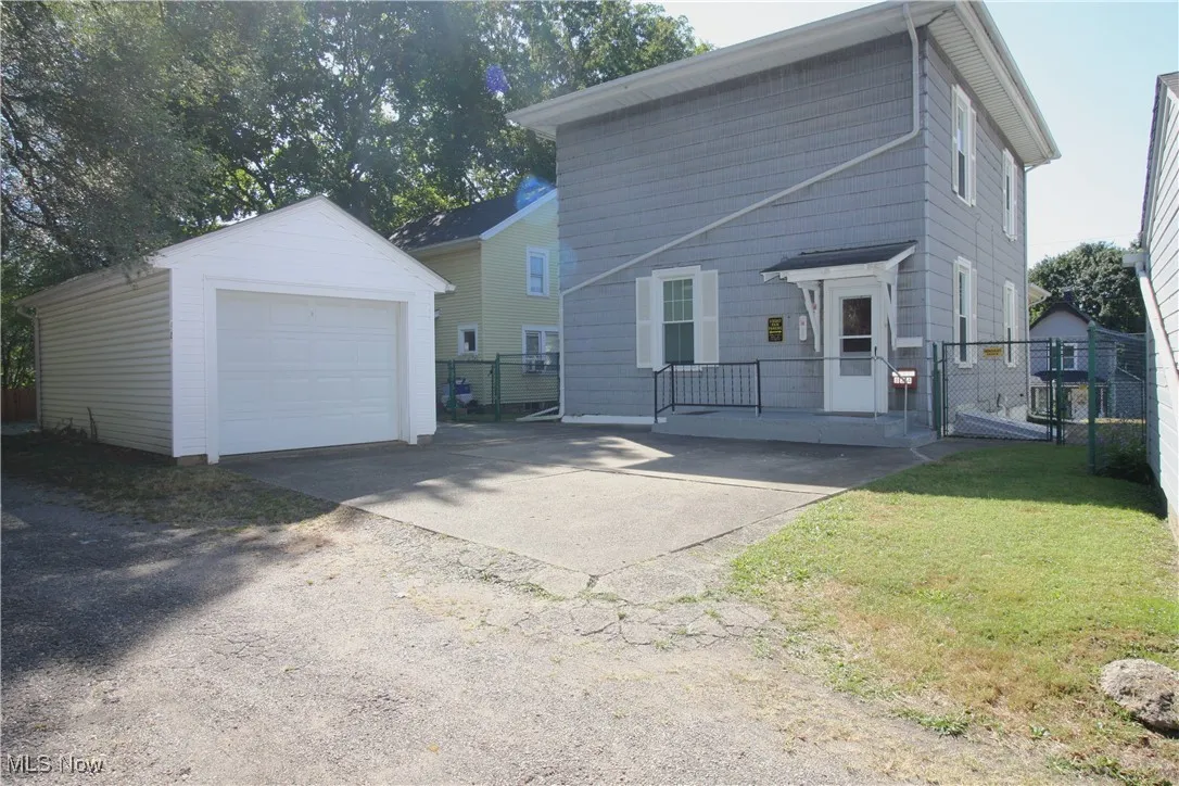 Back of home with garage and parking.