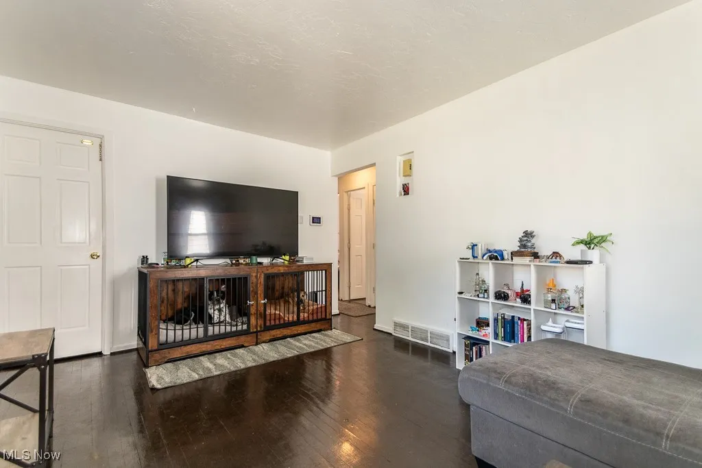 Living area with dark wood-type flooring and a textured ceiling