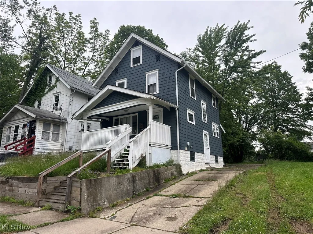 View of front of home with stairway and covered porch