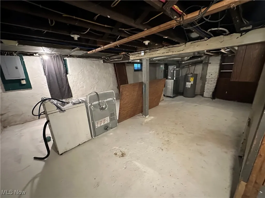 Basement with water heater, electric panel, and heating unit