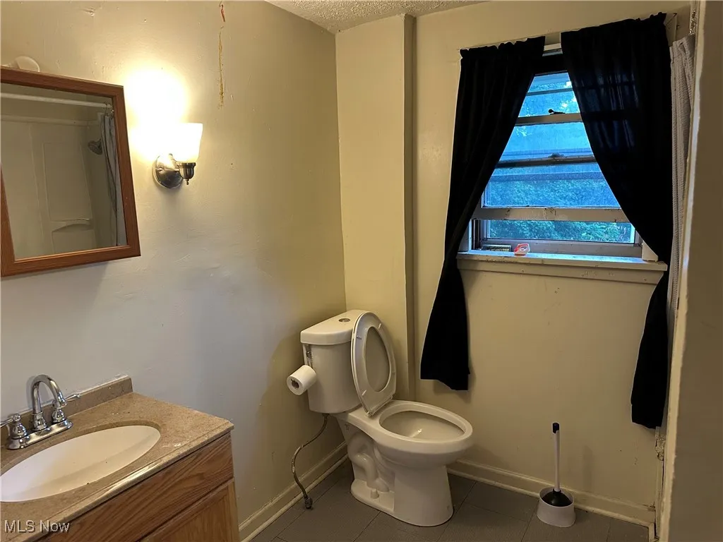 Bathroom featuring tile patterned floors, vanity, and a textured ceiling