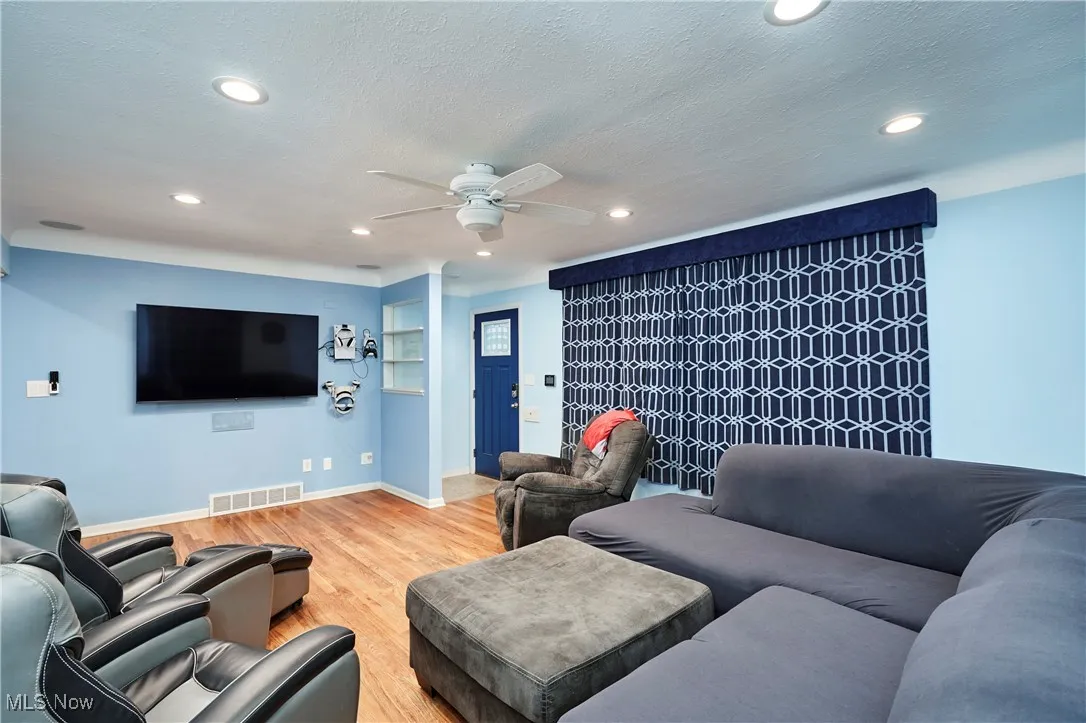 Living area with light hardwood flooring, ceiling fan, recessed lighting, and a textured ceiling
