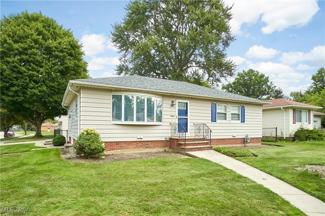 View of front of house with a front lawn and a shingled roof