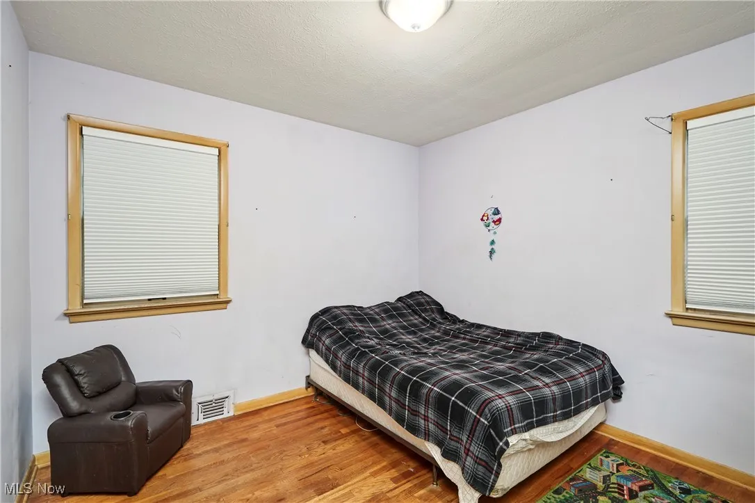 Bedroom featuring wood finished floors and a textured ceiling