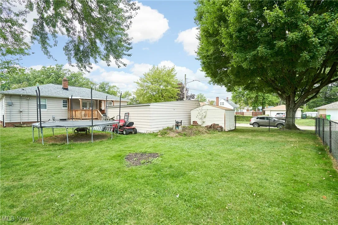 View of yard with a trampoline and a deck