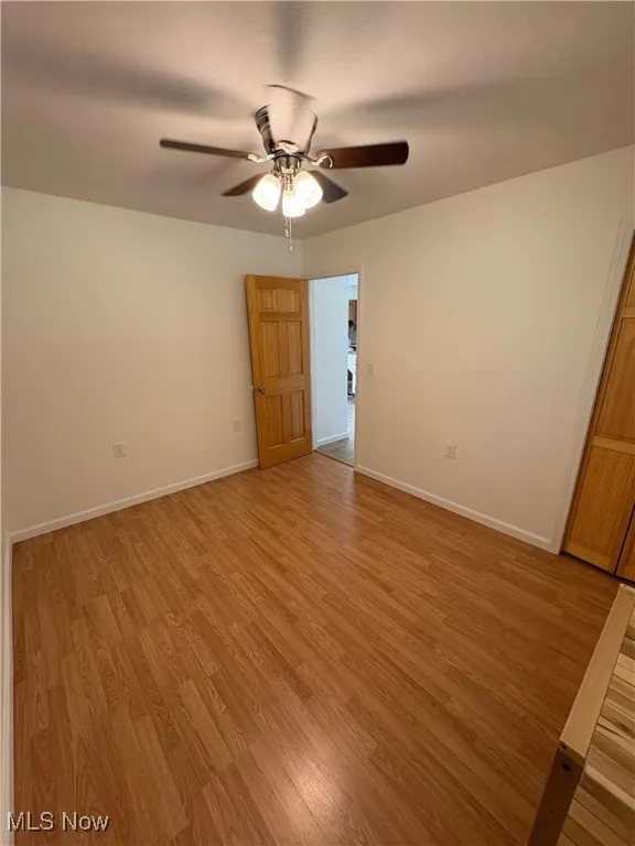 Empty room with light wood-style flooring and a ceiling fan