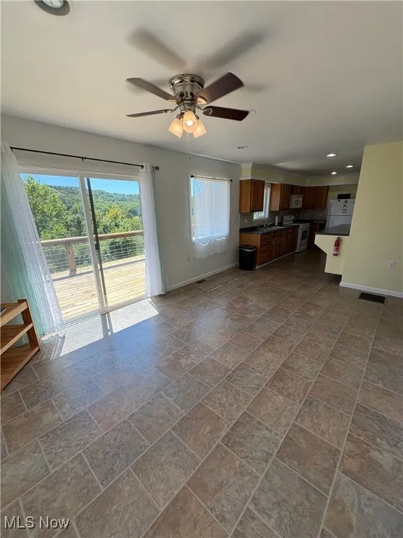 Unfurnished living room featuring recessed lighting, a ceiling fan, and dark stone finish flooring