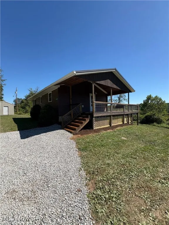 View of front of property featuring a deck and a front yard