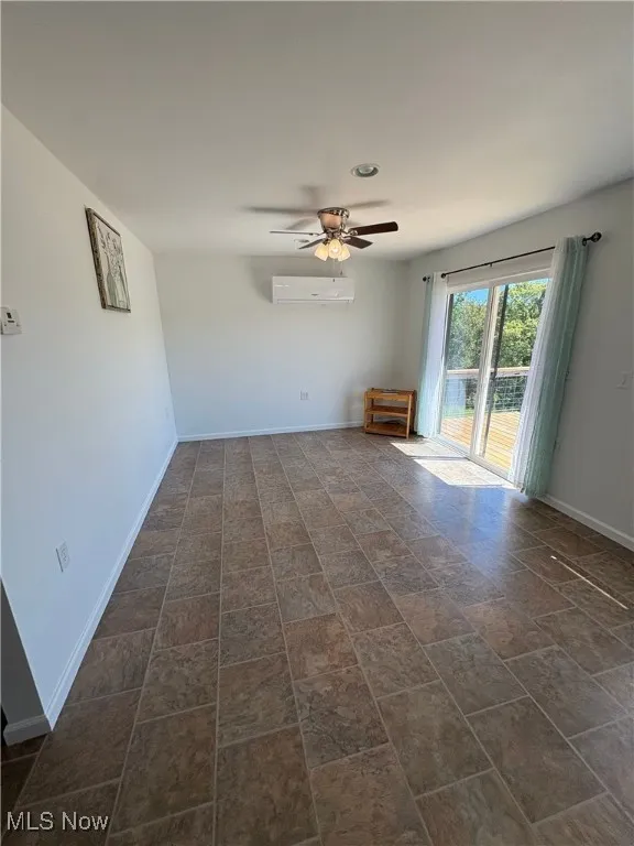 Empty room featuring baseboards and a ceiling fan