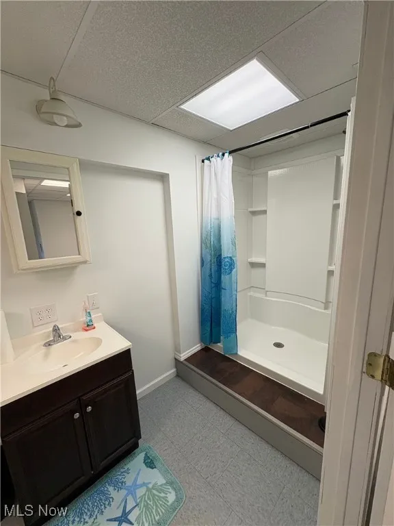 Bathroom featuring vanity, a shower stall, and light flooring