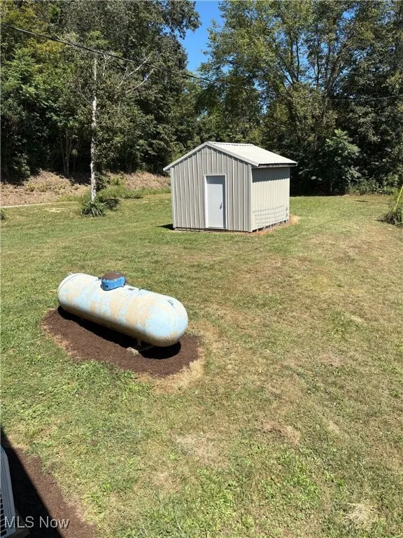 View of green lawn featuring a storage shed