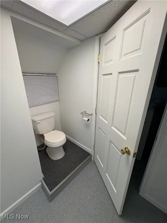Bathroom with baseboards and light floors