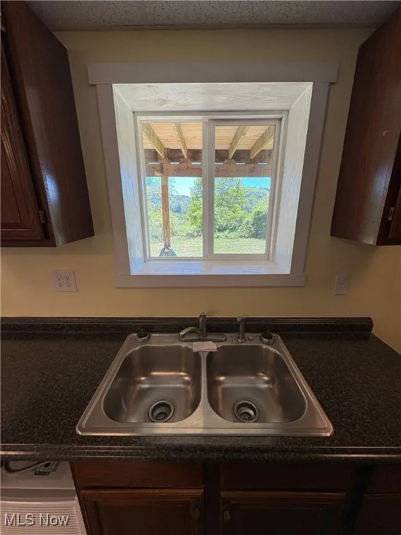 Kitchen view of dark countertops and dark brown cabinetry