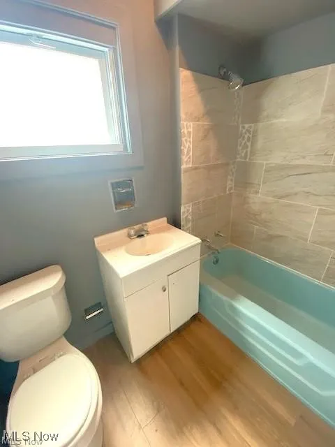 Bathroom featuring shower / bath combination, wood finished floors, and vanity