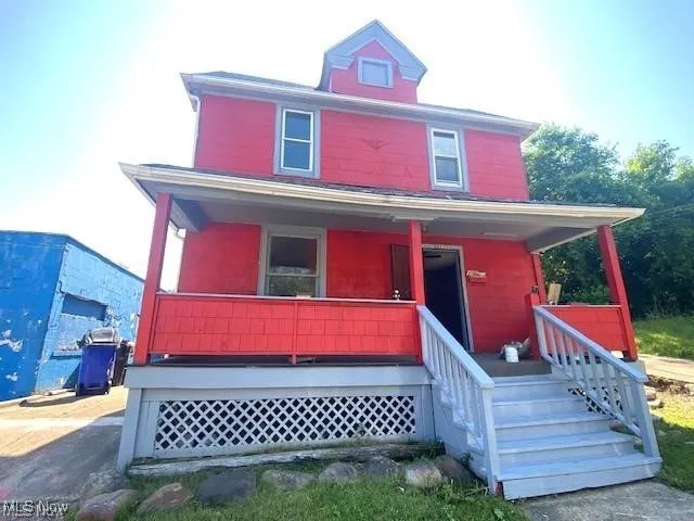 American foursquare style home featuring covered porch