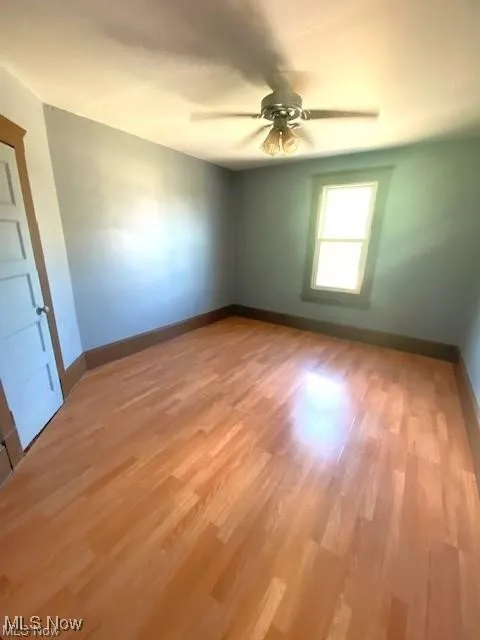 Empty room featuring light wood finished floors and a ceiling fan