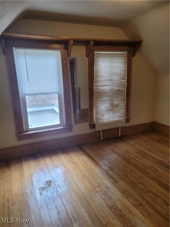 Bonus room with wood-type flooring and lofted ceiling