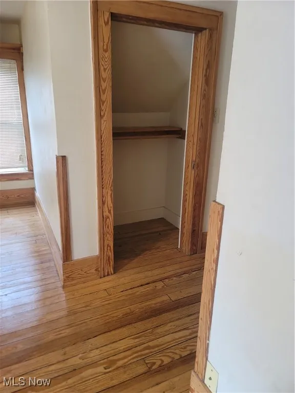 Hallway featuring light wood-type flooring and baseboards