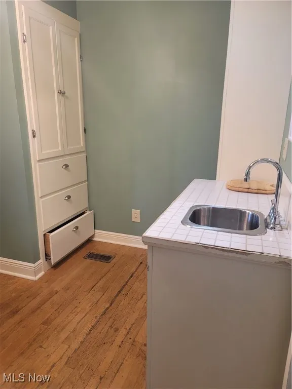 Laundry area with baseboards and light wood-type flooring