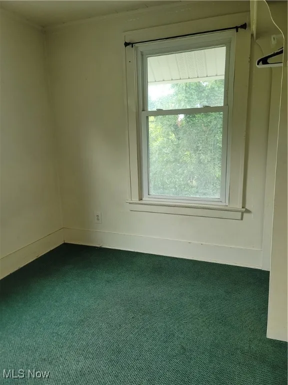Unfurnished room with carpet flooring and baseboards